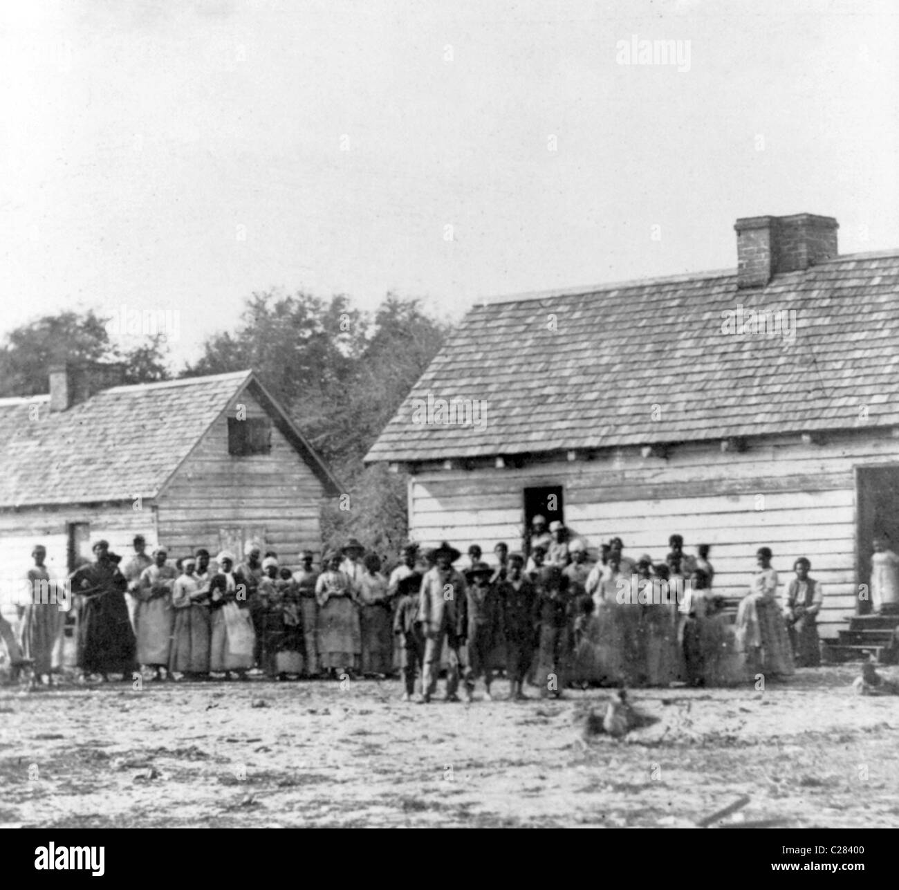 Gran grupo de esclavos de pie en frente de los edificios en Smith's Plantation, Beaufort, Carolina del Sur, Estados Unidos. 1862 Foto de stock