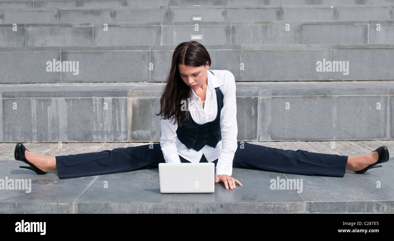 - Mujer de negocios flexible con portátil Foto de stock