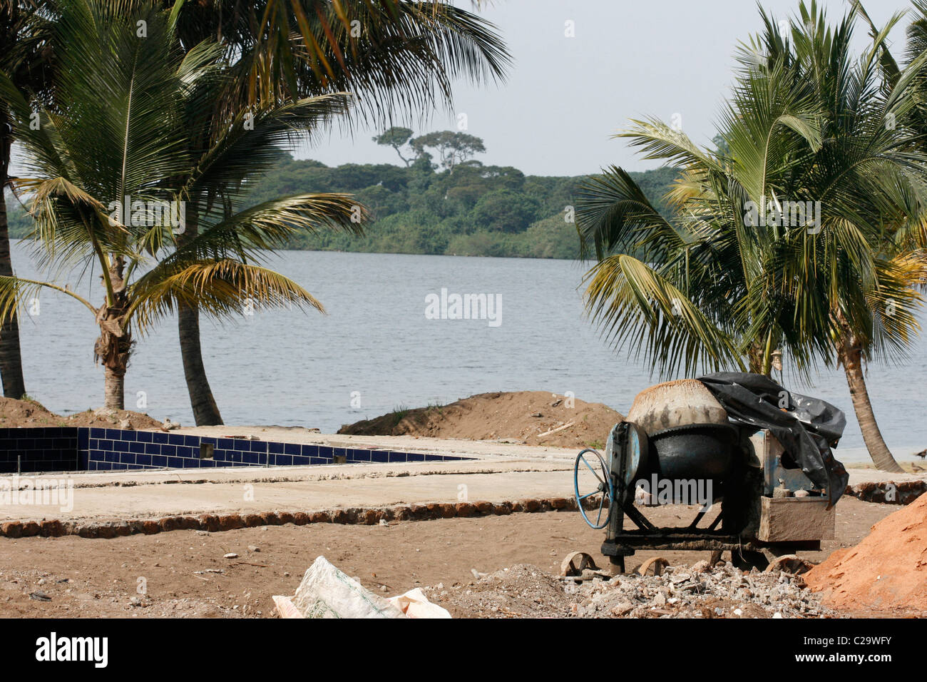 Una mezcladora de cemento en un sitio en construcción en una isla en el Lago Victoria, Uganda. Hay una piscina en construcción Foto de stock