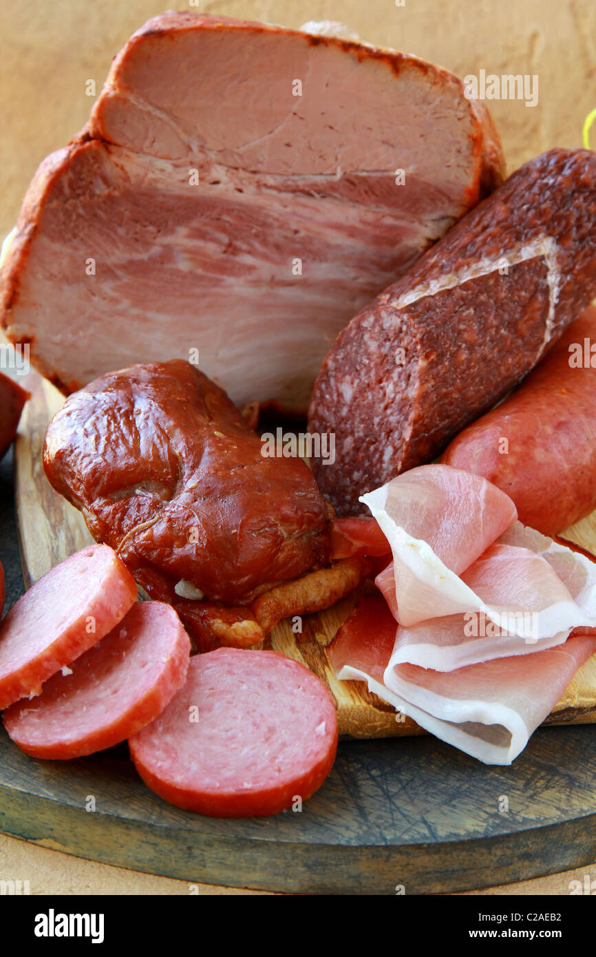 Surtido de varios tipos de salchichas y carnes ahumadas sobre una tabla