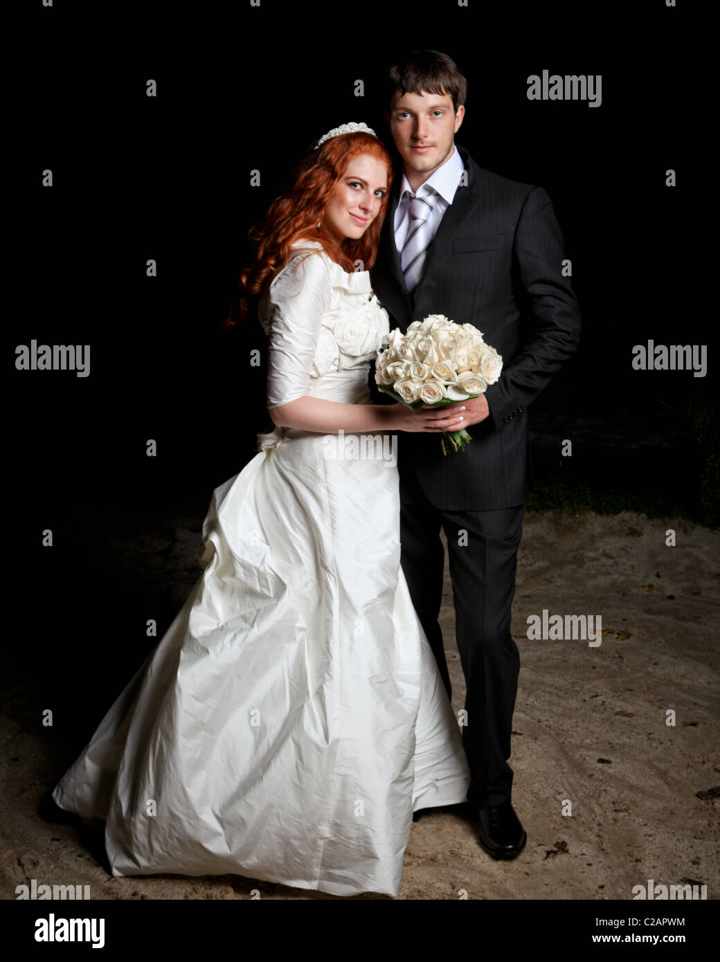 La novia y el novio en el día de su boda. Banco del río en la noche. Estado de Nueva York. Modelo de liberación firmado. Foto de stock