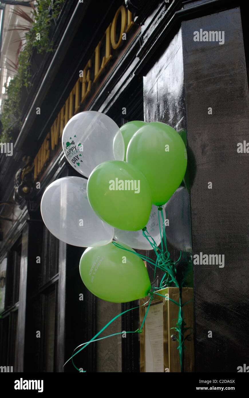 Verde y globos blancos marcando el Día de San Patricio. Fuera de un pub en Covent Garden. Londres. Inglaterra Foto de stock