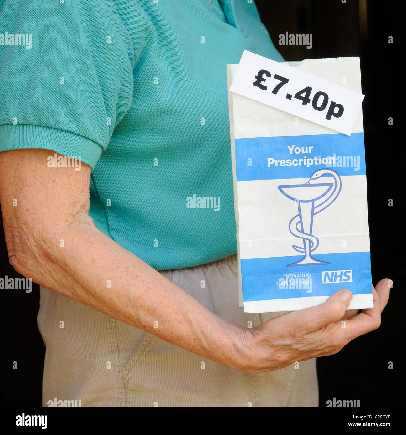 Paciente mujer sosteniendo NHS paquete de prescripción que tiene un cargo de £7.40p por tema Foto de stock