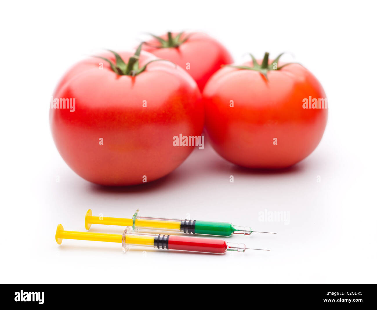 Tres Tomates con syrigne. Útil para la modificación genética conceptos. Foto de stock