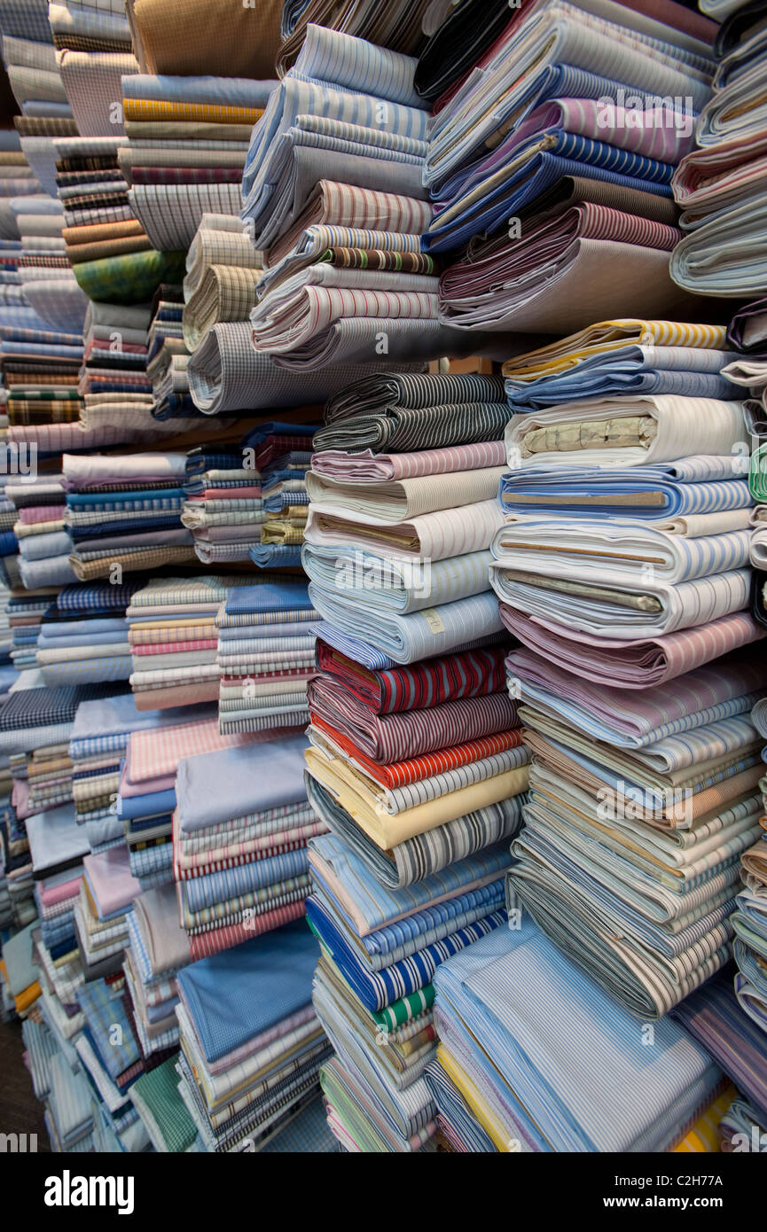 Una amplia variedad de material para camisas a medida en una tienda de sastres en Orchard Road, Singapur Foto de stock