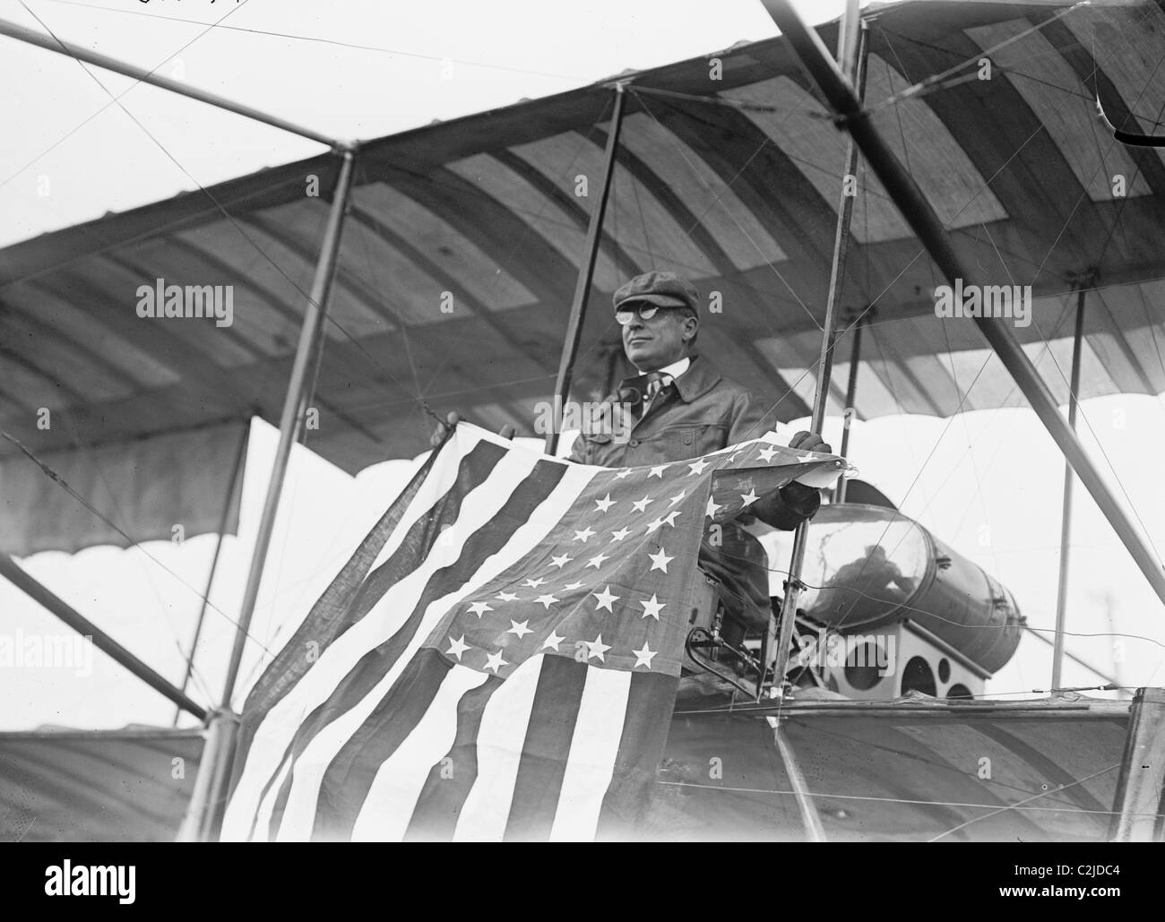 Aviador C.B. Harmon desenrolla Stars & Stripes desde su asiento del piloto en su biplano. Foto de stock