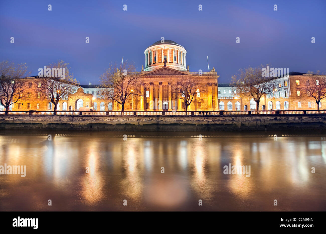 Una vista a lo largo del río Liffey Dublín al anochecer con los cuatro tribunales con destacada Foto de stock
