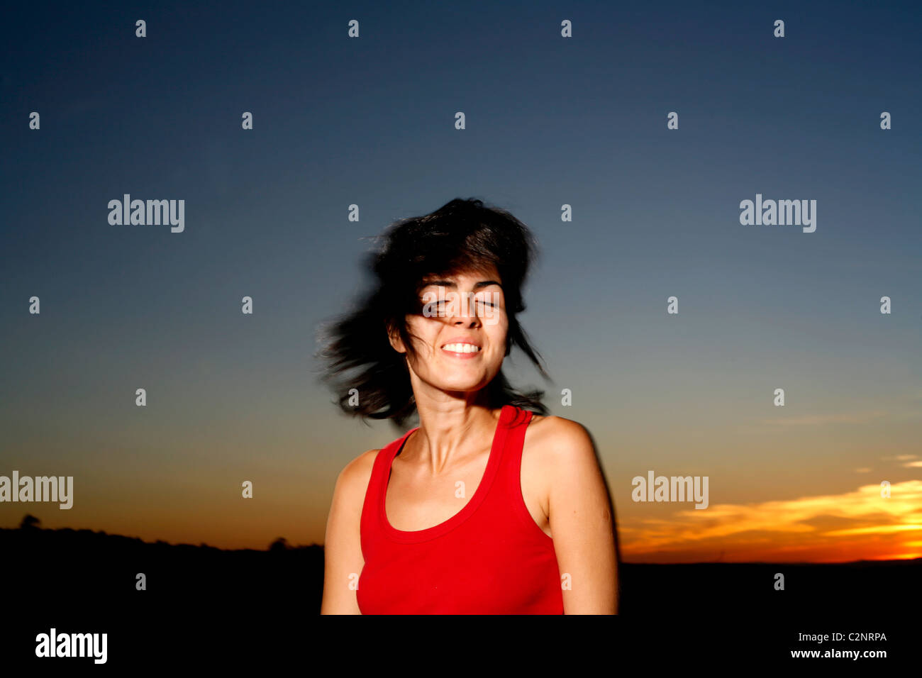Mujer latina con el cabello oscuro y el atardecer Foto de stock