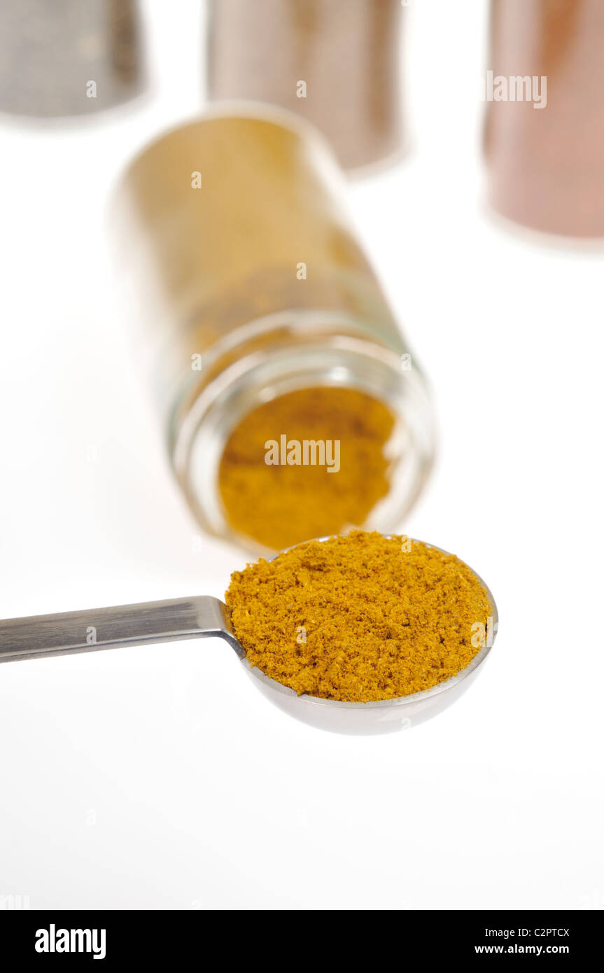 Cacito dosificador lleno con las especias curry con otras hierbas y  especias en frascos de fondo en blanco Fotografía de stock - Alamy