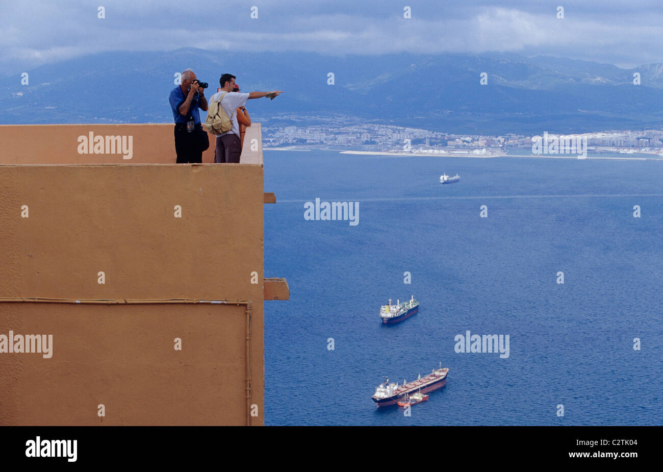 Los turistas señalando hitos desde un punto de observación en la cima del Peñón de Gibraltar Foto de stock