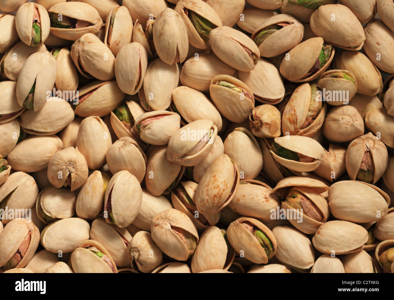 Antecedentes de los pistachos tostados en sus conchas con iluminación lateral Foto de stock