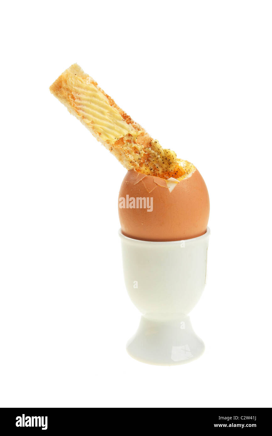 Huevos y tostadas con mantequilla soldado en una huevera Foto de stock