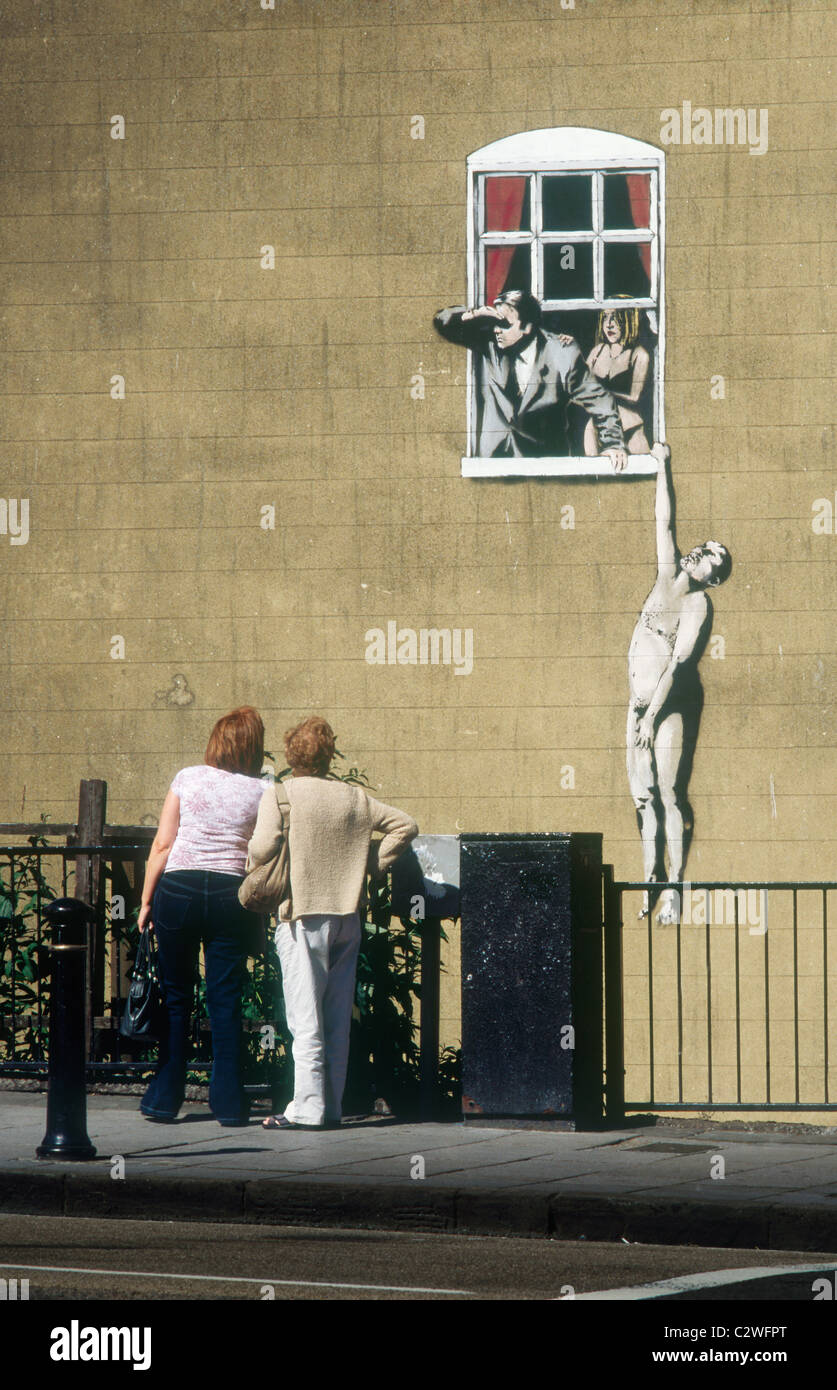 La pintura de la pared por Banksy de hombre desnudo colgando de repisa de  la ventana Park Street Bristol Fotografía de stock - Alamy
