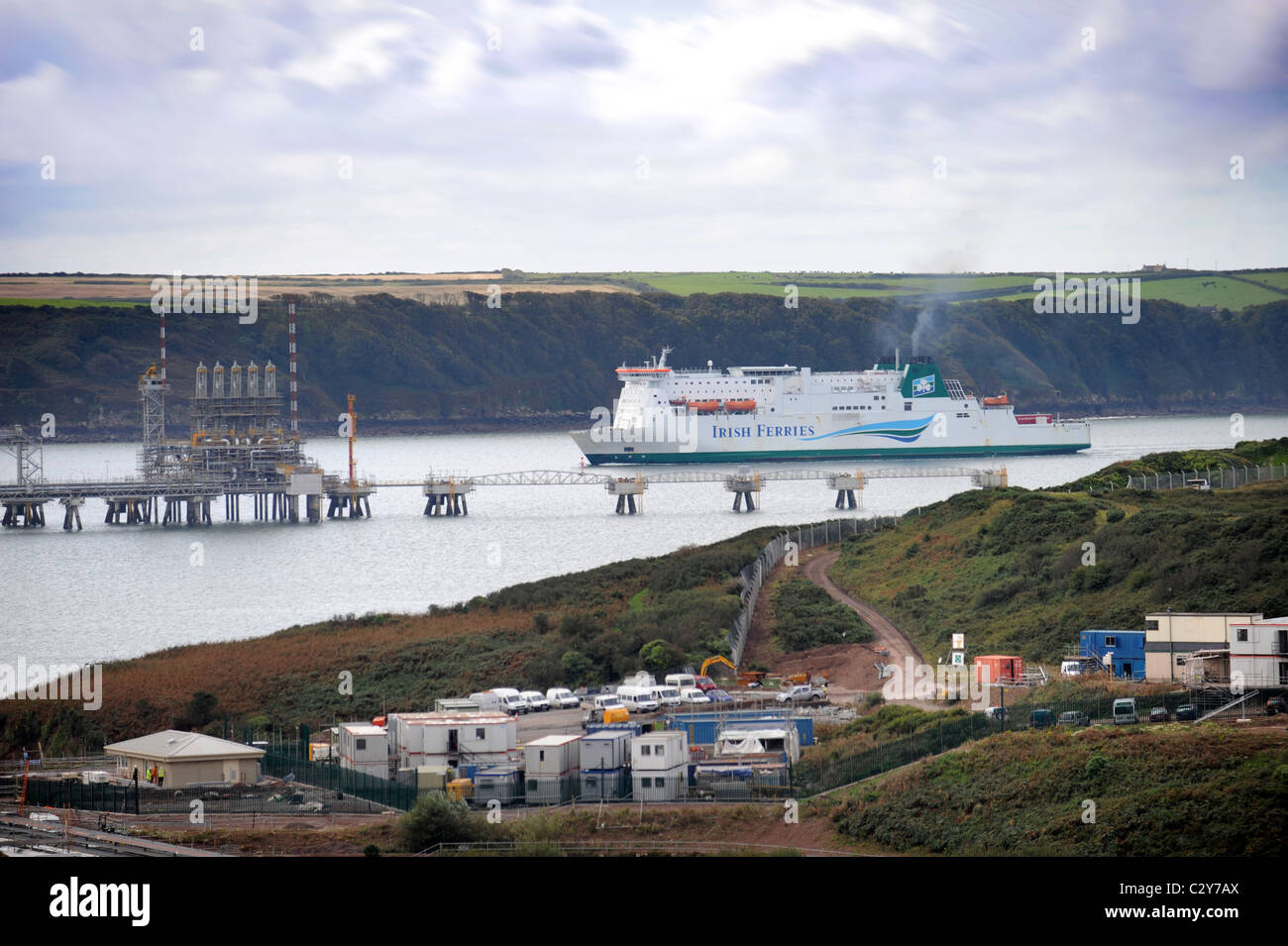 Vista desde Milford Haven con amarres de refinería de petróleo y un barco de pasajeros Irish Ferries Gales UK Foto de stock