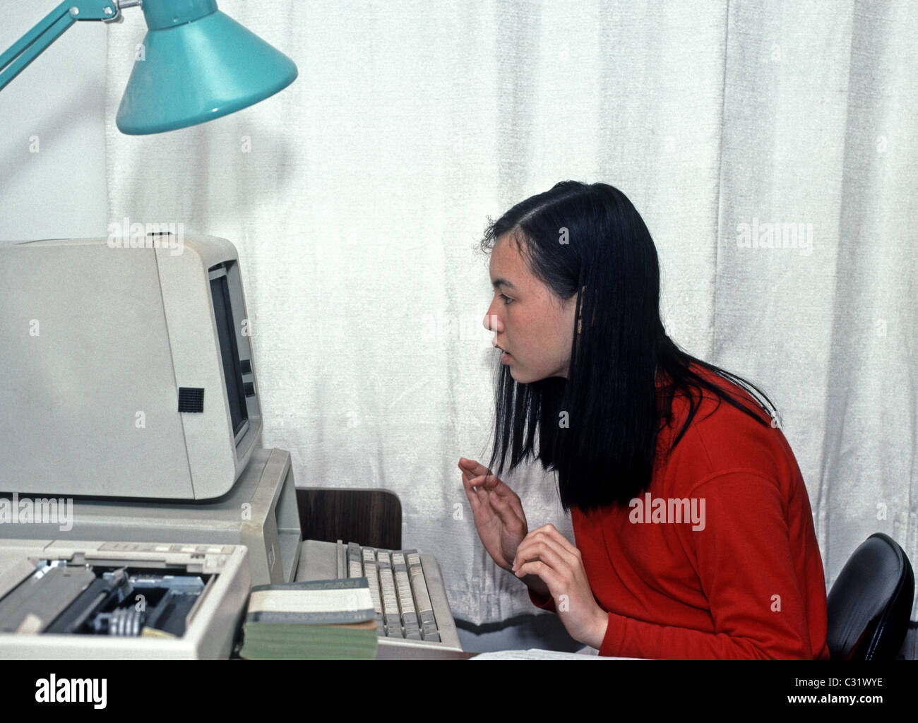 Chica utilizando un ordenador PC a domicilio Foto de stock