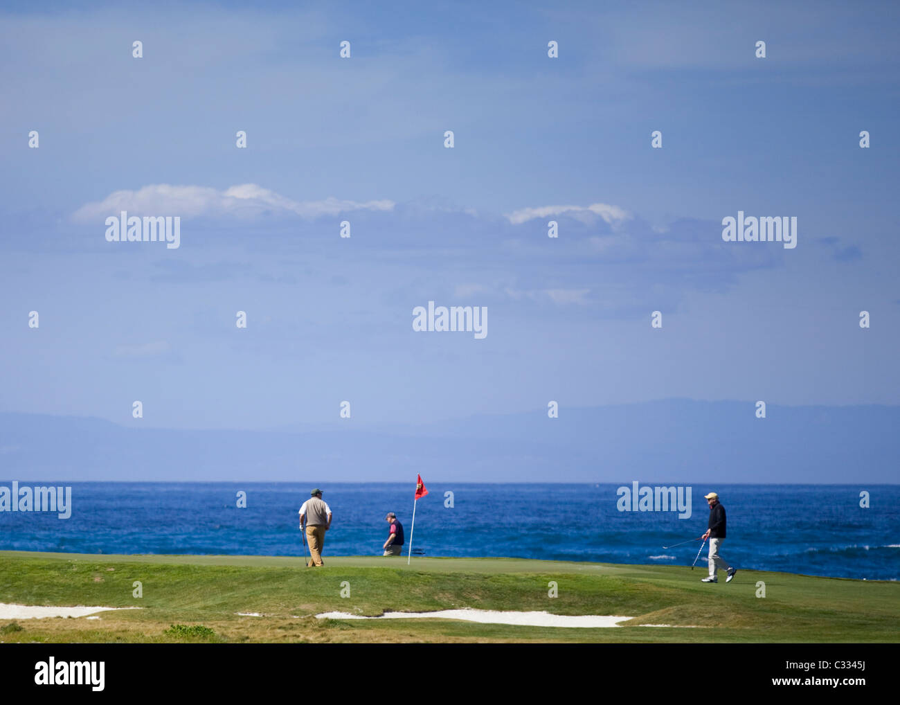 Los golfistas en el putting green en el famoso campo de golf Pebble Beach Oceanfront Foto de stock