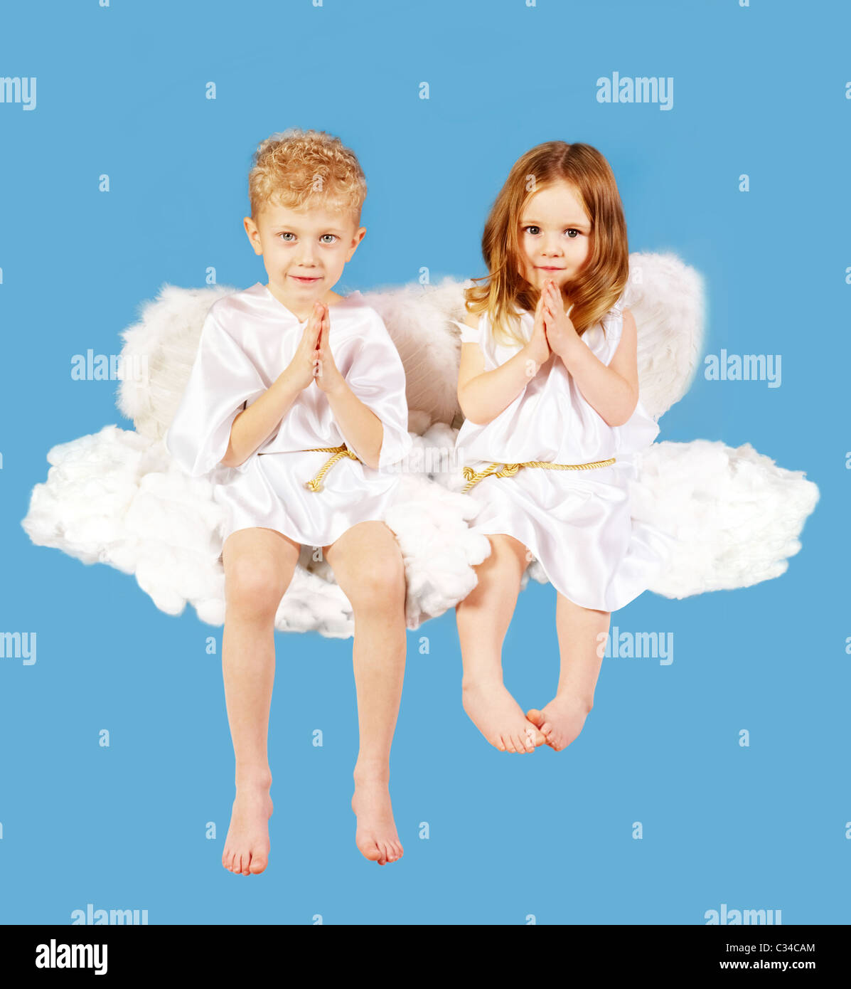 Retrato de dos lindos ángeles sentados en la nube. Foto de stock
