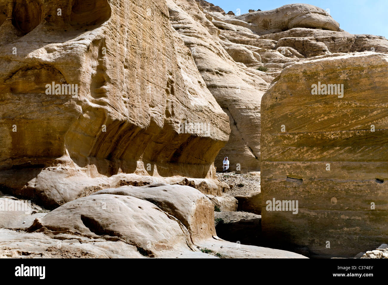 Un hombre jordano se encuentra entre las rocas de la rosa roja en la ciudad de Petra. Jordania Foto de stock