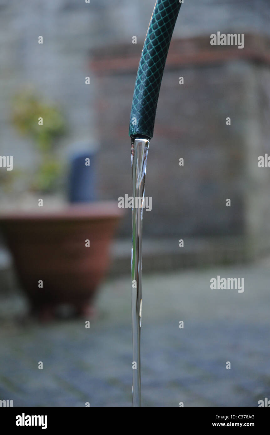 Grifo de agua gotea desde una manguera de jardín Foto de stock