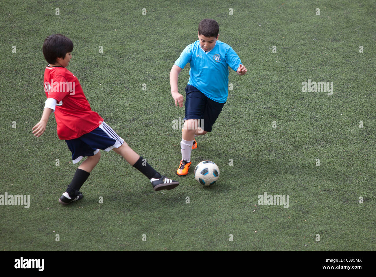 La acción del juego de fútbol del muchacho. Foto de stock