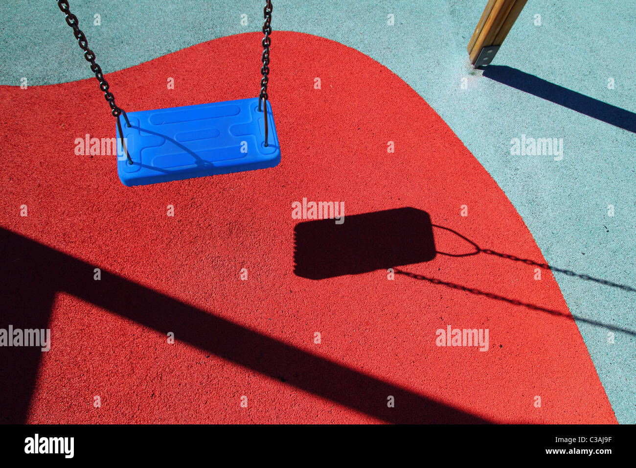 Parque azul o rojo giro piso parque infantil con sombras Foto de stock