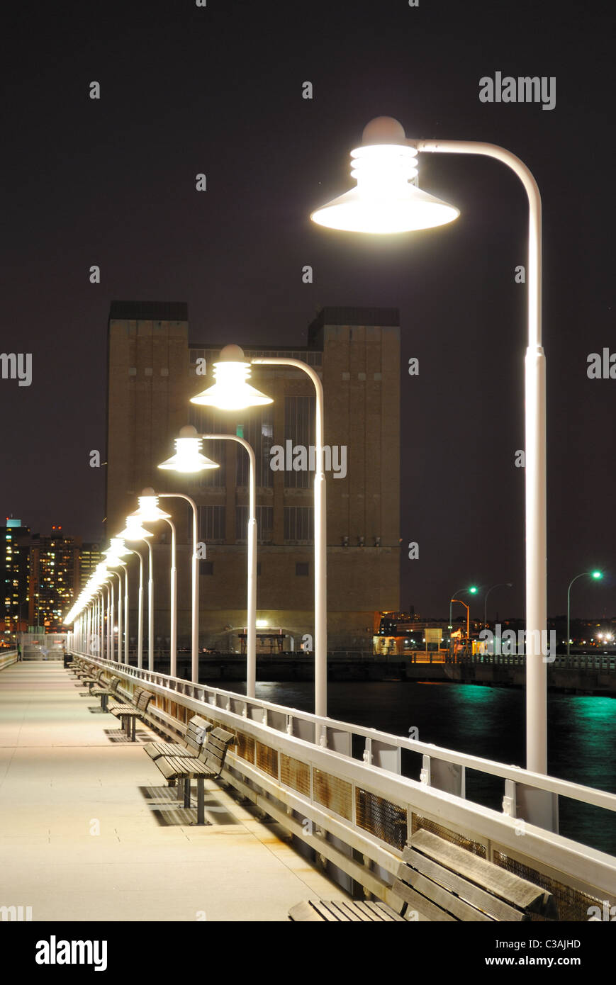 Largo muelle con luces en la distancia. Foto de stock