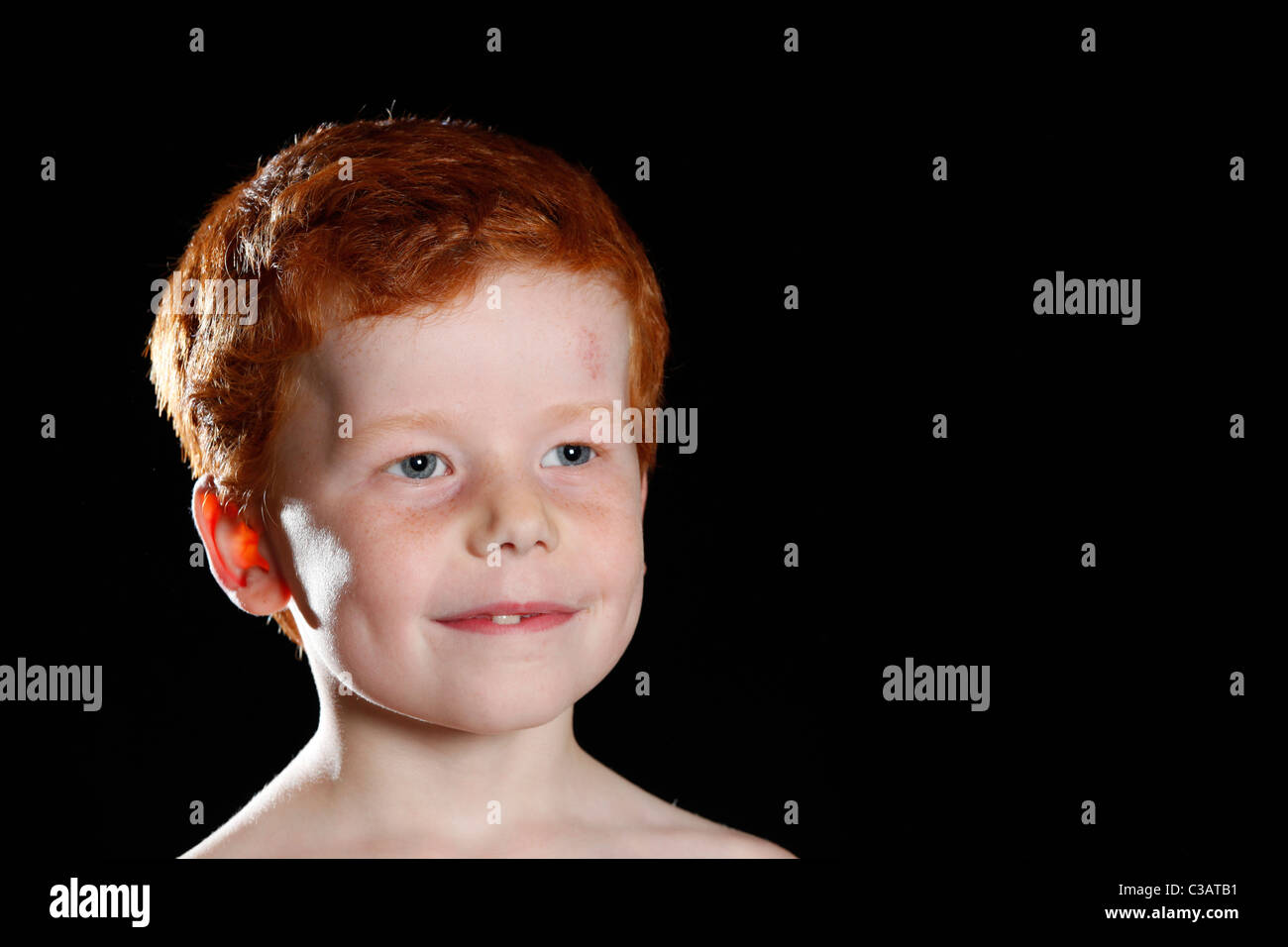 Retrato de un niño de siete años con el pelo rojo y ojos azules. Foto de stock
