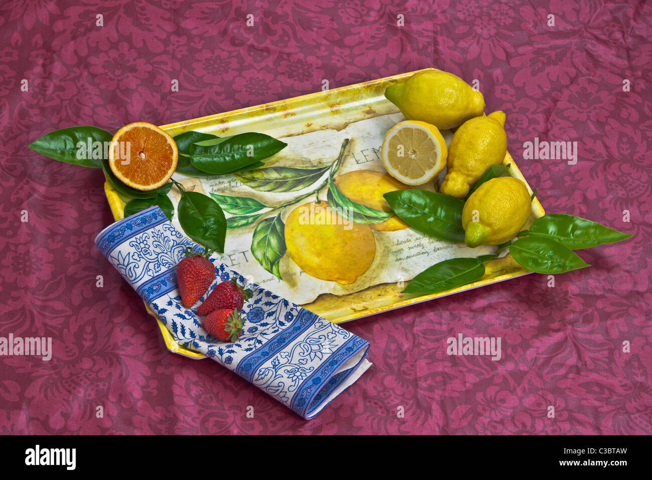 Una bandeja con naranjas, limones y fresas. Foto de stock