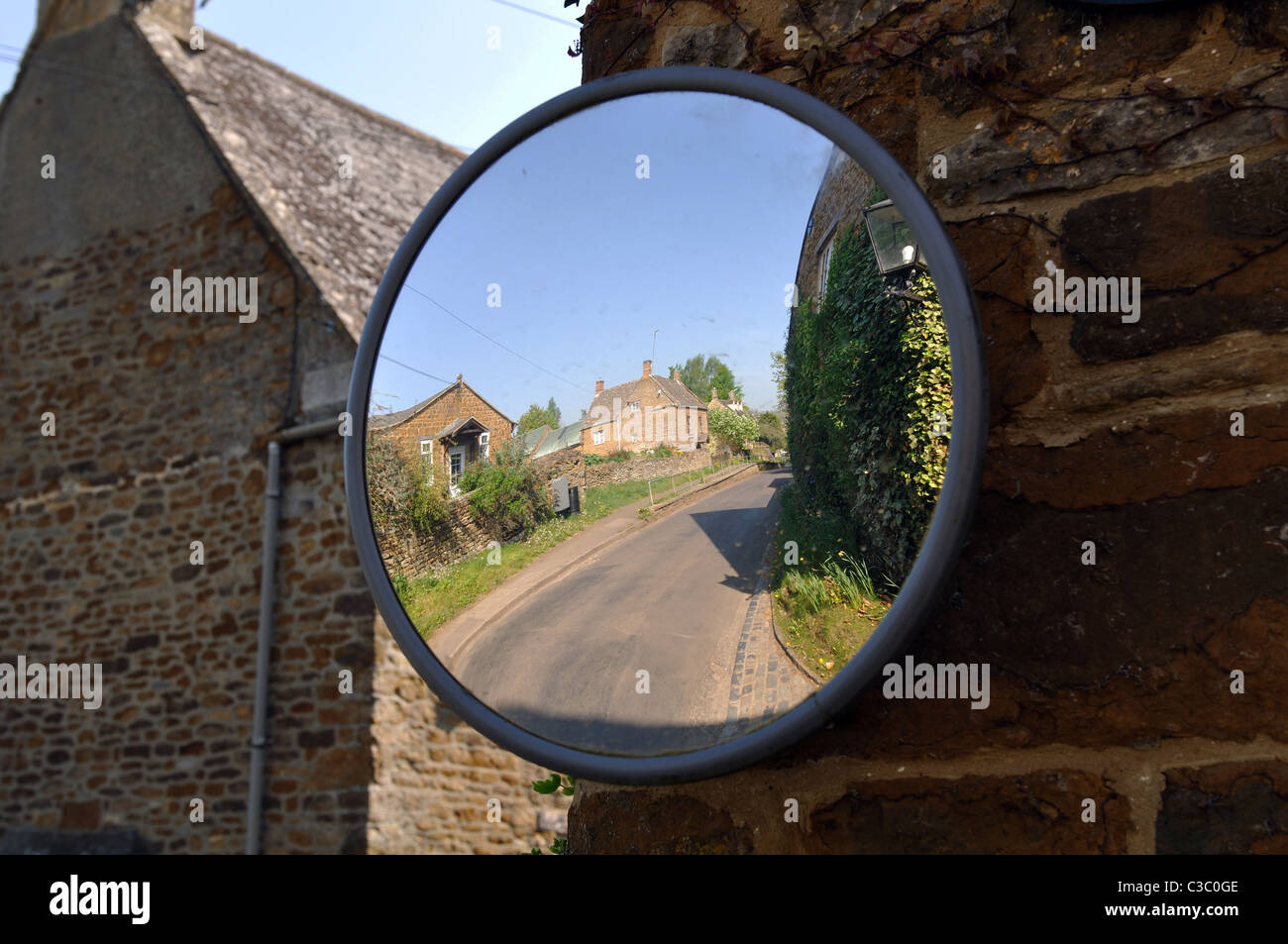 Espejo convexo para facilitar la visibilidad de los automovilistas en un pueblo Foto de stock