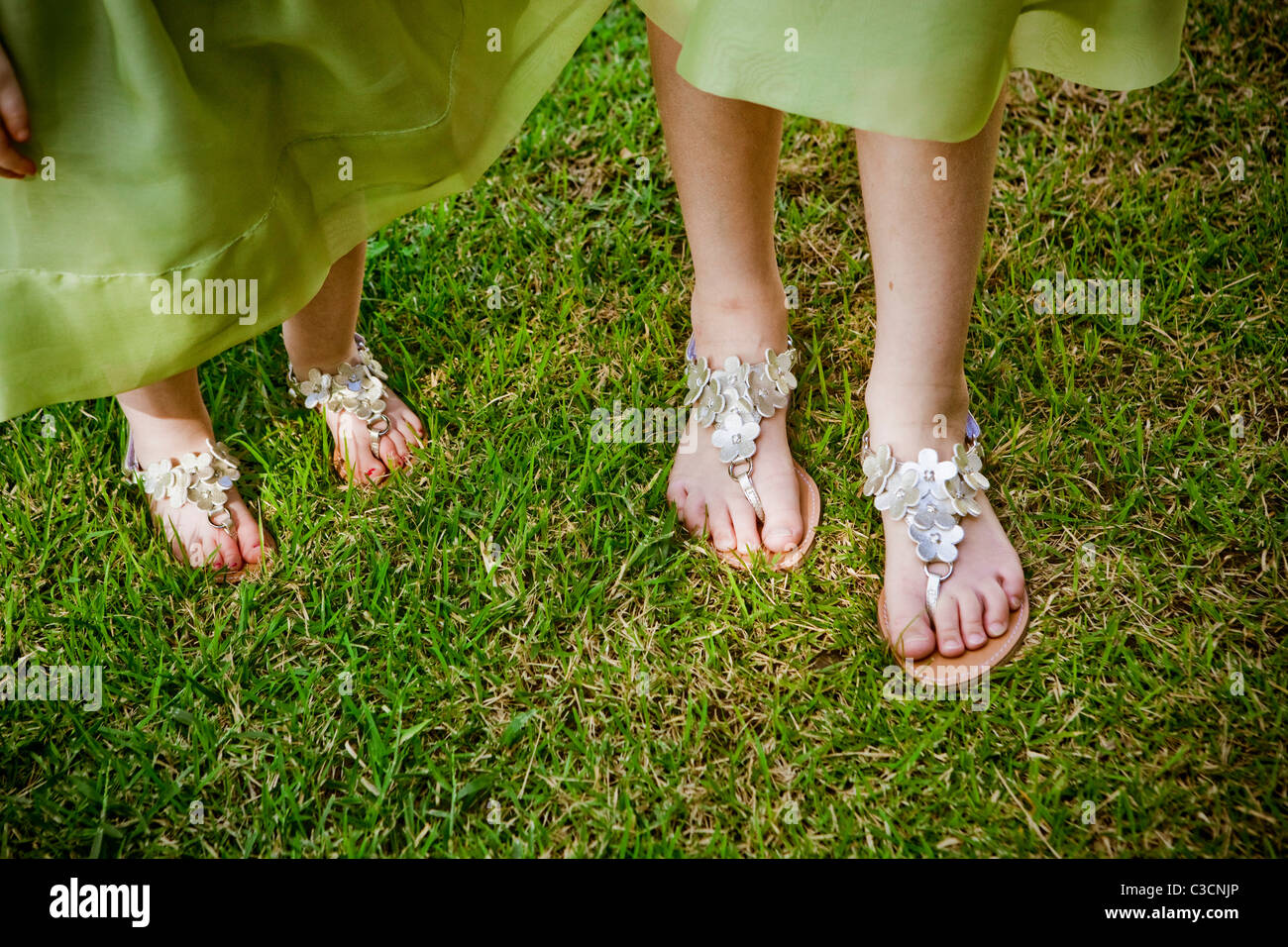 Dos pares de pies en sandalias de plata Fotografía de stock - Alamy