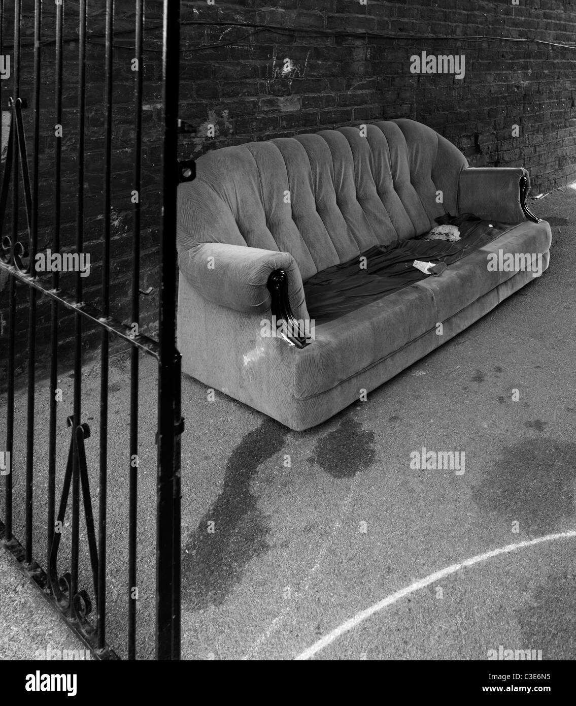 Viejo sofá tirado en callejón Foto de stock