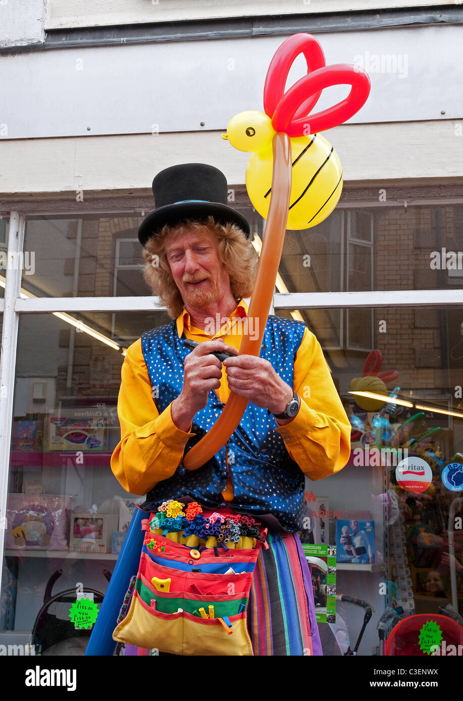 Un artista callejero haciendo modelos de globo en Camborne, Cornualles, en el Reino Unido Foto de stock