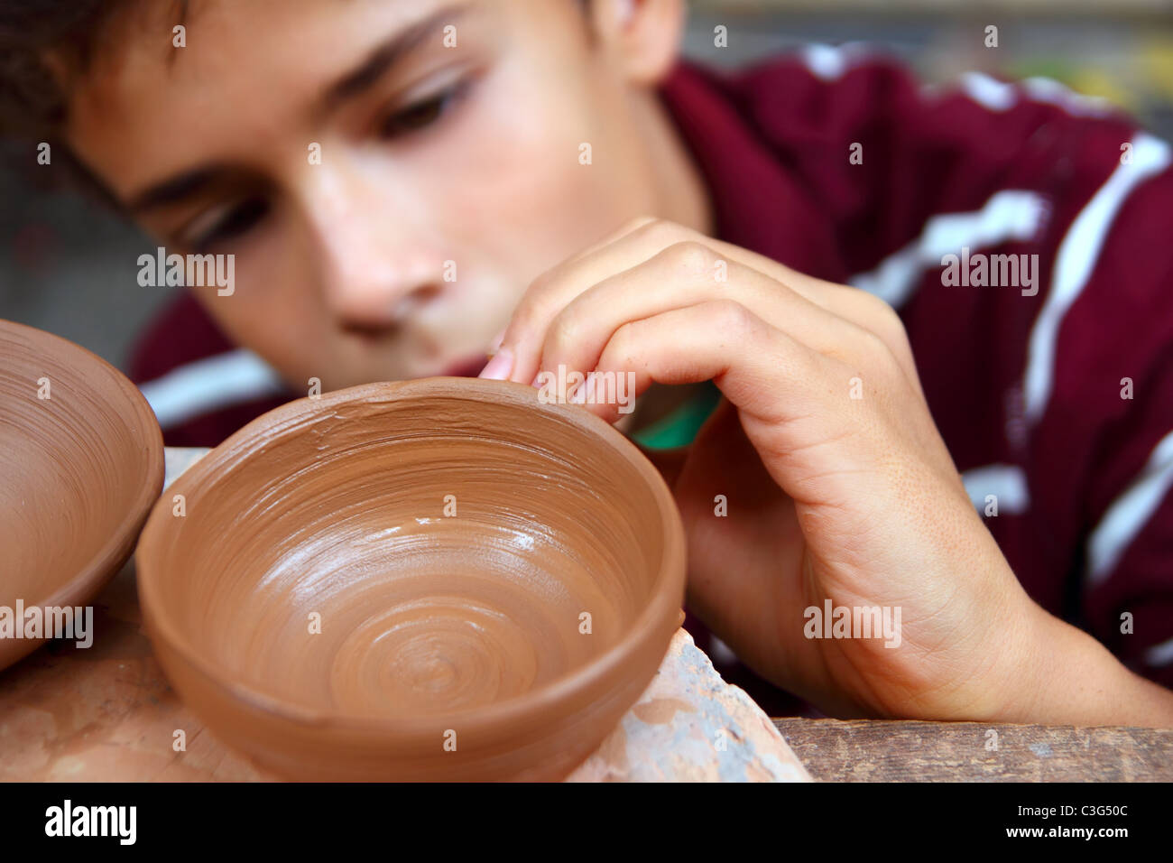 Boy teen potter tazón de arcilla trabajan en alfarería tradicional arte Foto de stock