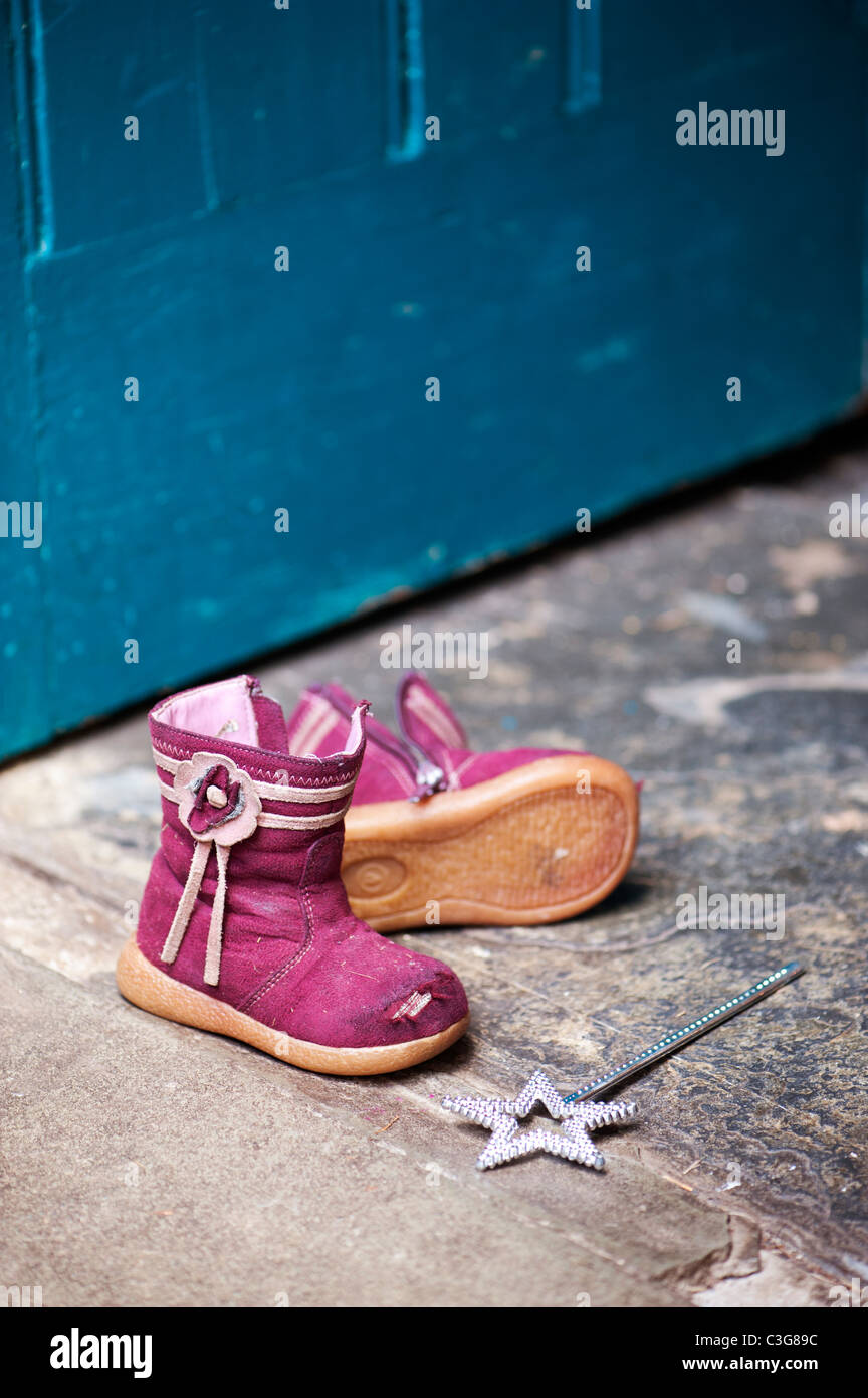 Jóvenes muchachas Hada varita mágica y botas desgastadas en una puerta Foto de stock
