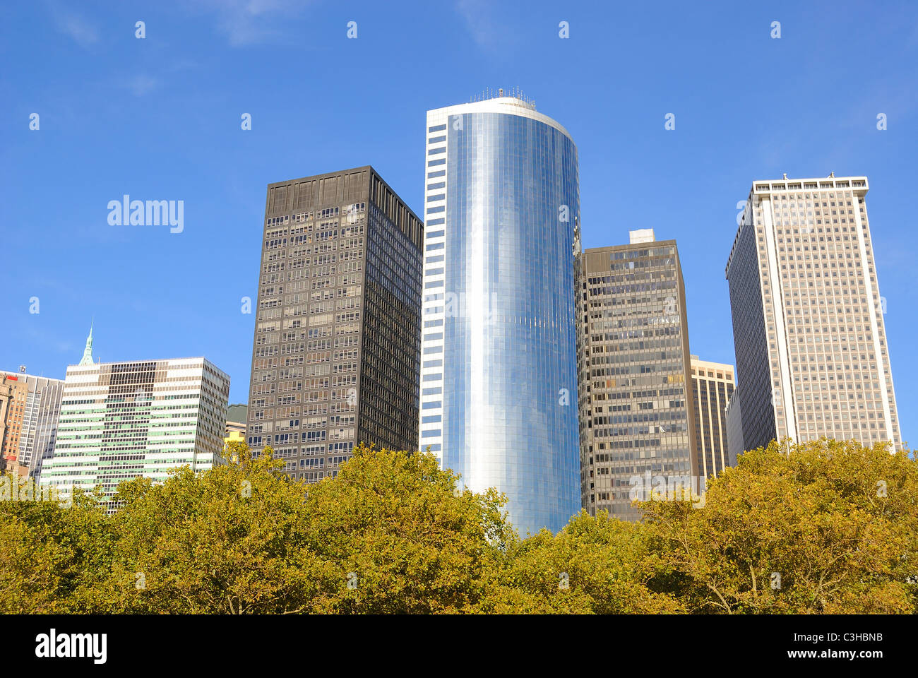 La arquitectura moderna del centro de Manhattan, tal como se ve desde el parque Battery árboles. Foto de stock
