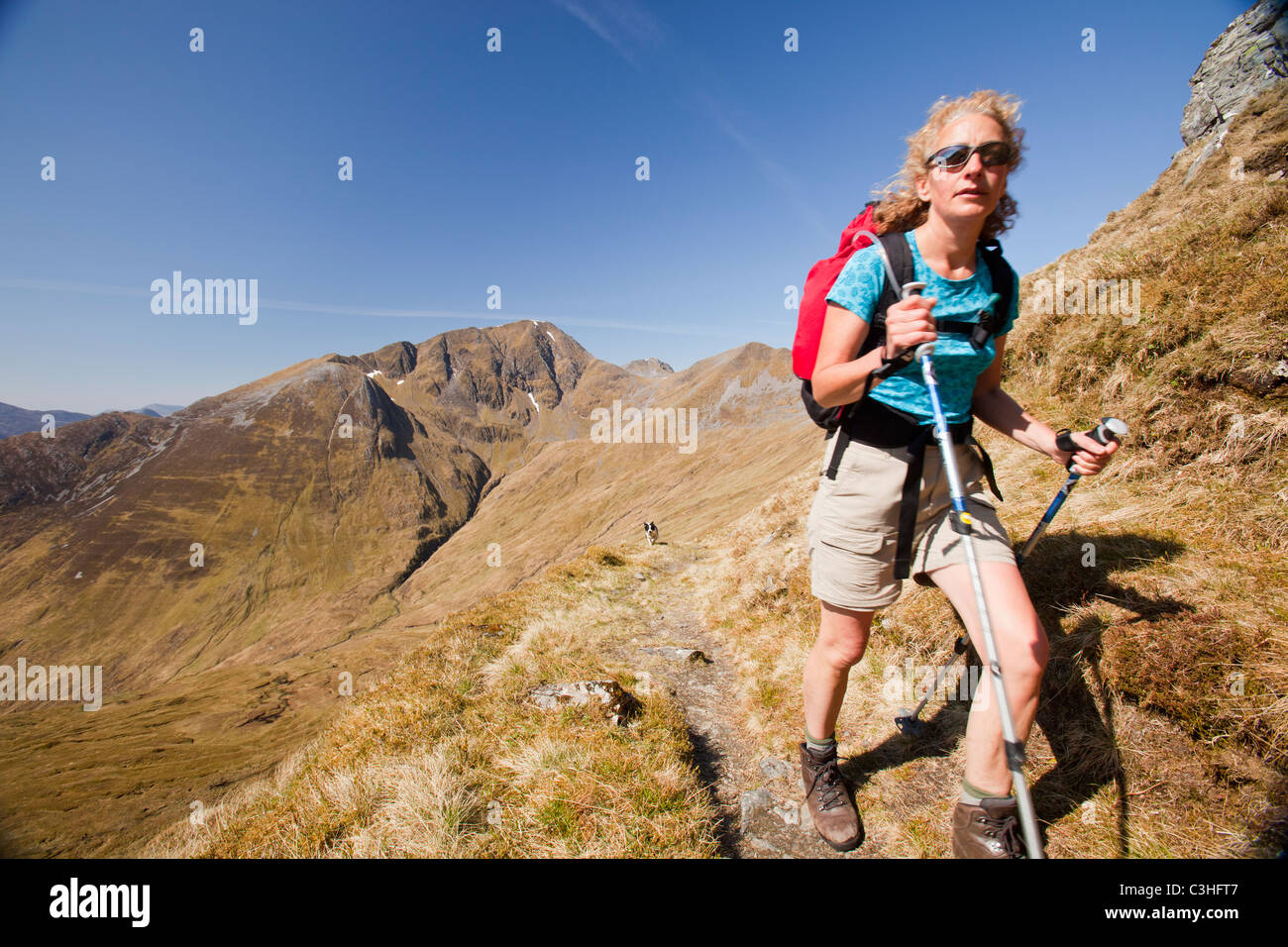 Mujer joven haciendo senderismo por un camino embarrado Stock Photo