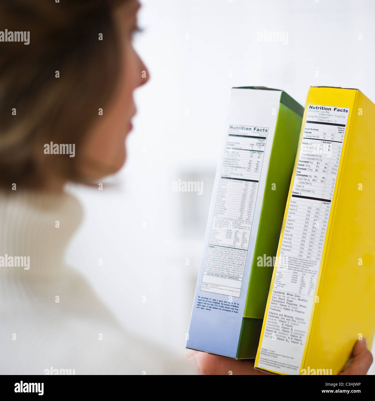 Mujer comparando las etiquetas de nutrición Foto de stock