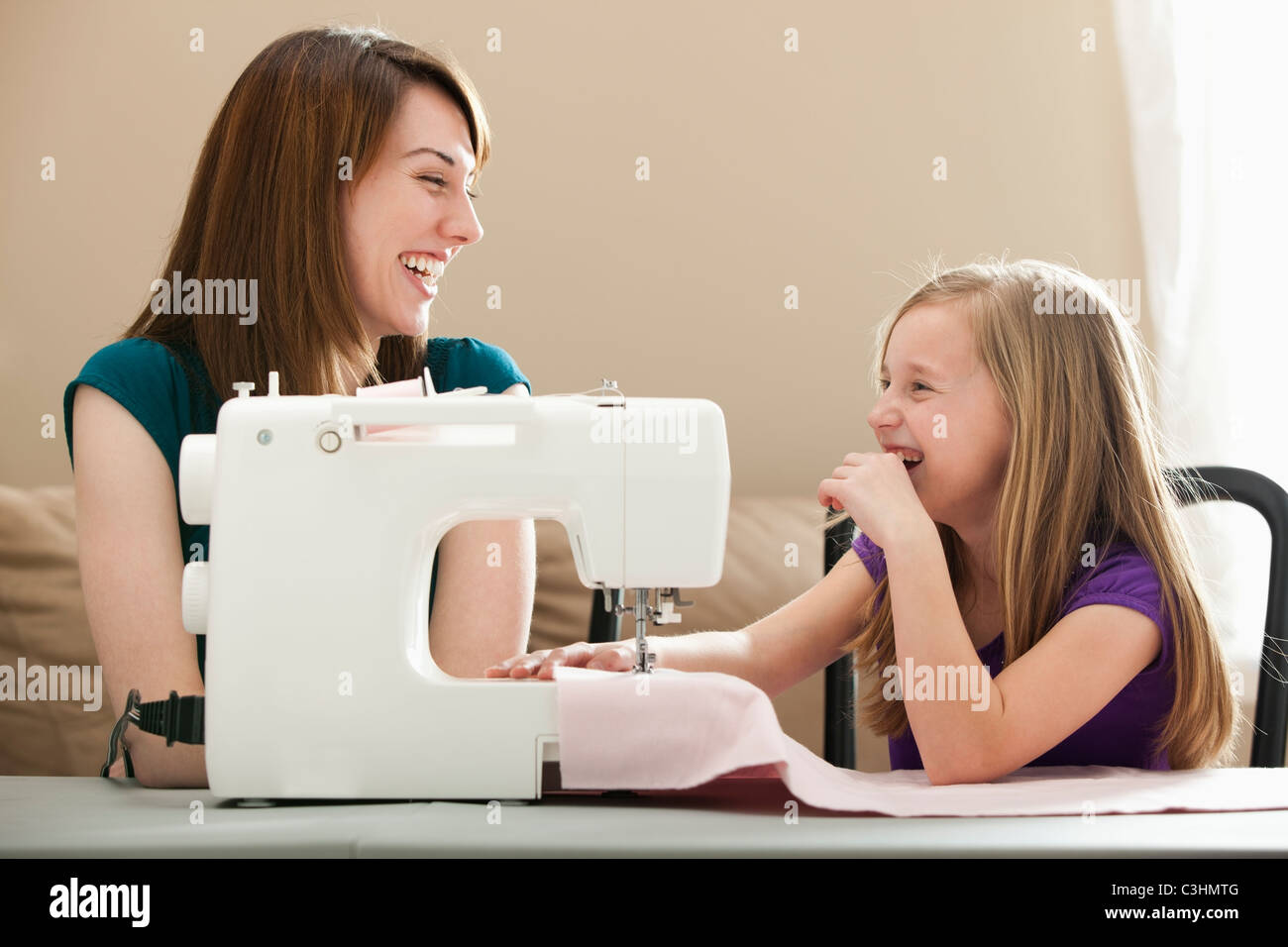 Chica (8-9) y joven con máquina de coser Fotografía de stock - Alamy