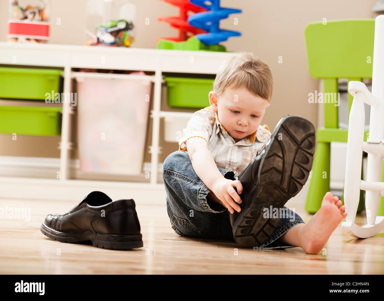 Boy (2-3) poner en los zapatos de papá Fotografía de stock - Alamy
