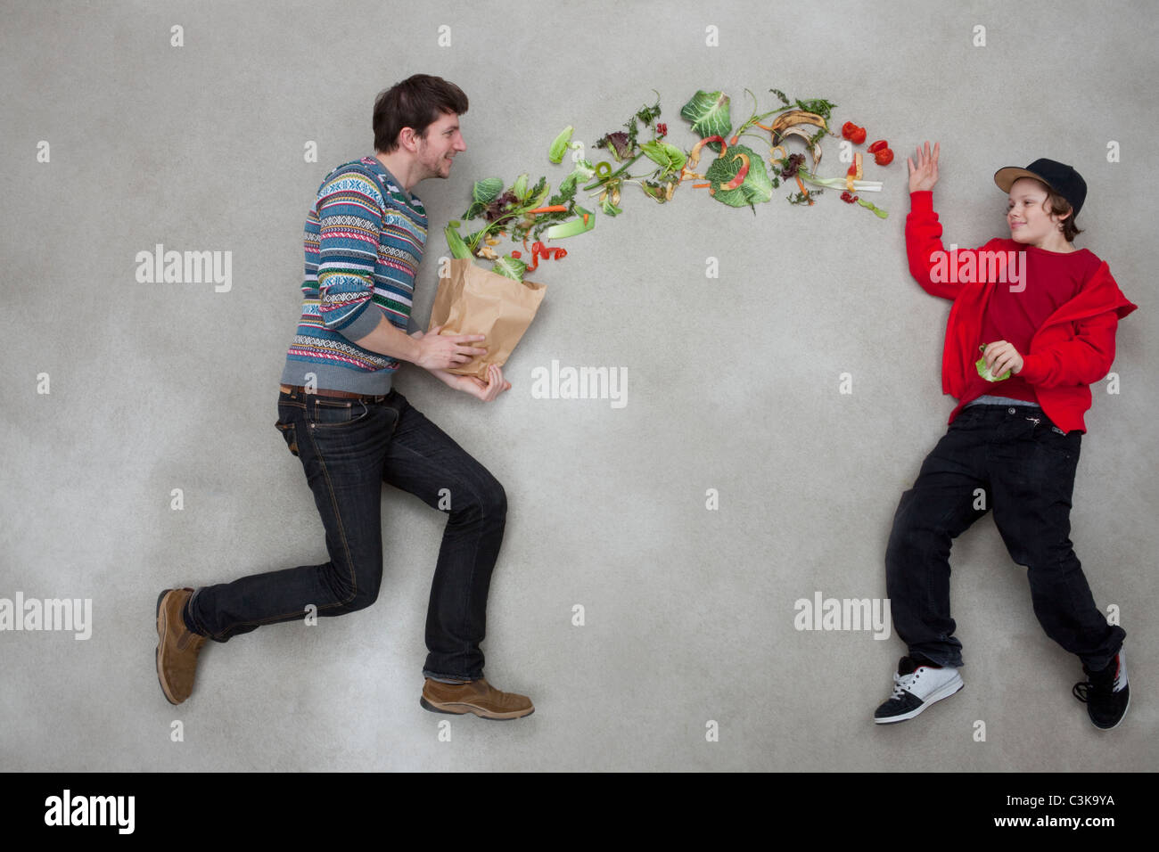El hombre y el muchacho equilibrando las verduras Foto de stock