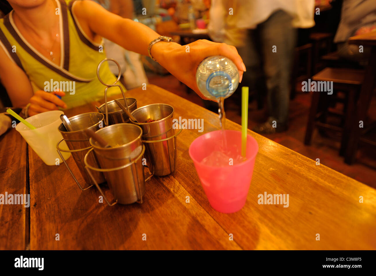 Señora tailandesa verter agua , restaurante , Bangkok, Tailandia Foto de stock