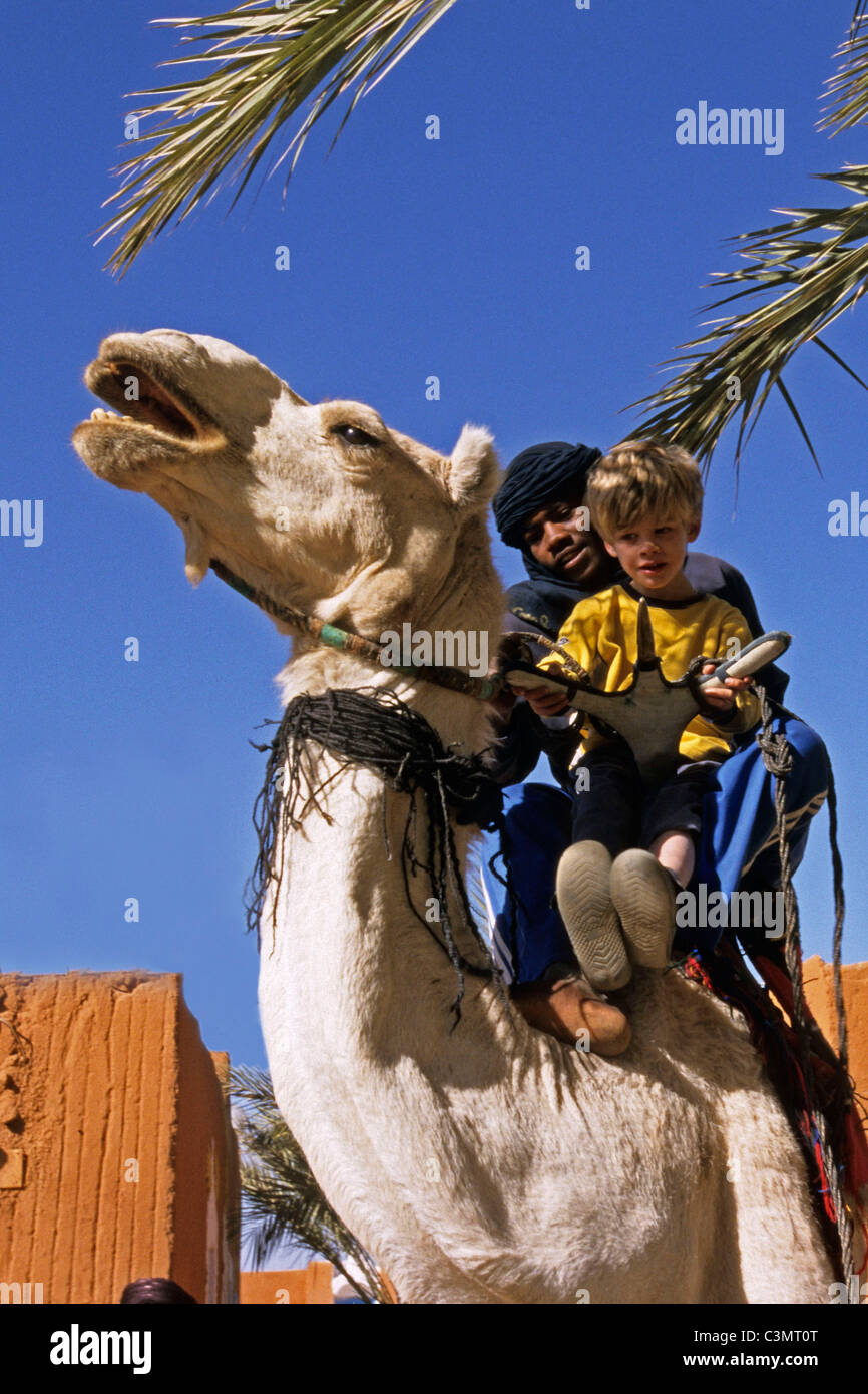 Argelia. Tamanrasset. El desierto del Sahara. Chico y Hombre de la tribu Tuareg en camello. Foto de stock
