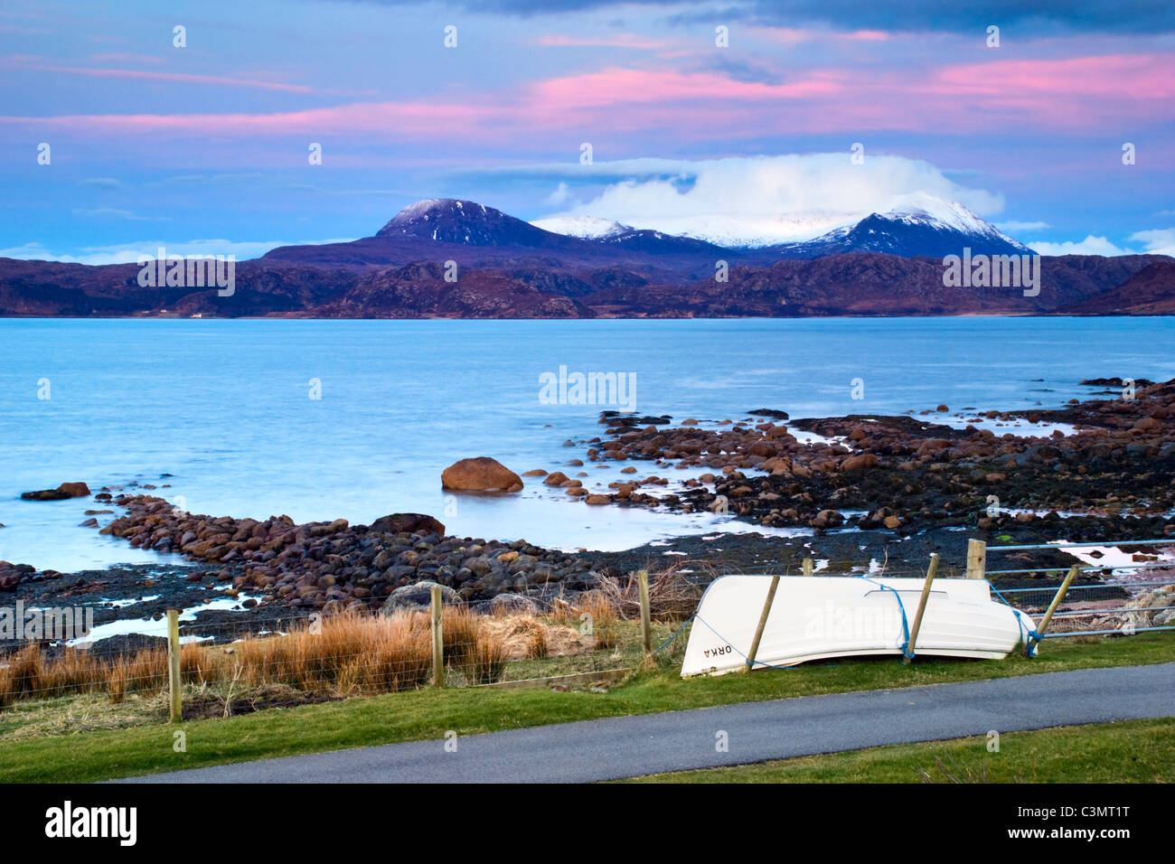 Mirando a través de la bahía de Gruinard Mellon Udrigle, Laide, Wester Ross, Escocia con rosa y azul del atardecer y pequeños botes Foto de stock
