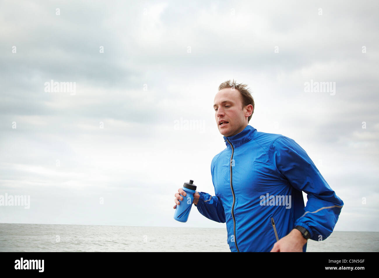 Hombre corriendo por el mar el día nublado Fotografía de stock - Alamy