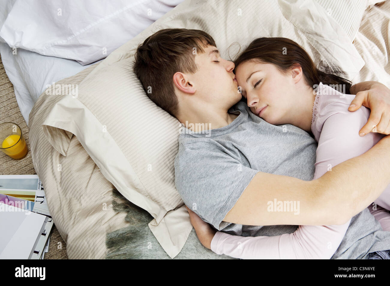 Pareja abrazada, sentando en la cama Fotografía de stock - Alamy