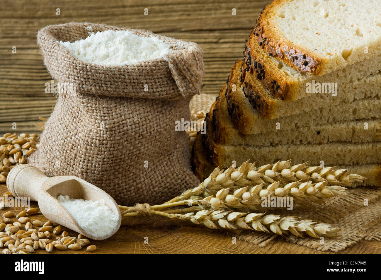 Pan casero fresco y harina en la pequeña bolsa de arpillera Foto de stock