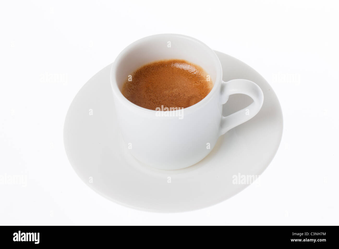 Un café espresso en una taza y plato blanco sobre fondo blanco. Foto de stock