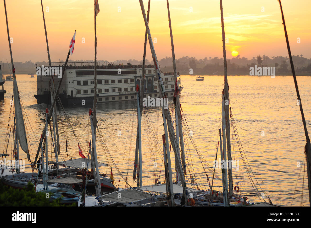 África y Oriente Próximo Egipto Luxor egipcio un barco crucero por el río Nilo cabezas al atardecer Foto de stock