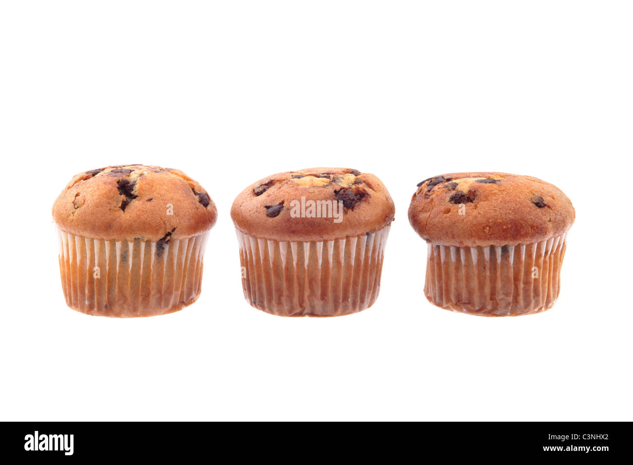 Tres muffins de chocolate en una línea aislado sobre un fondo blanco. Foto de stock