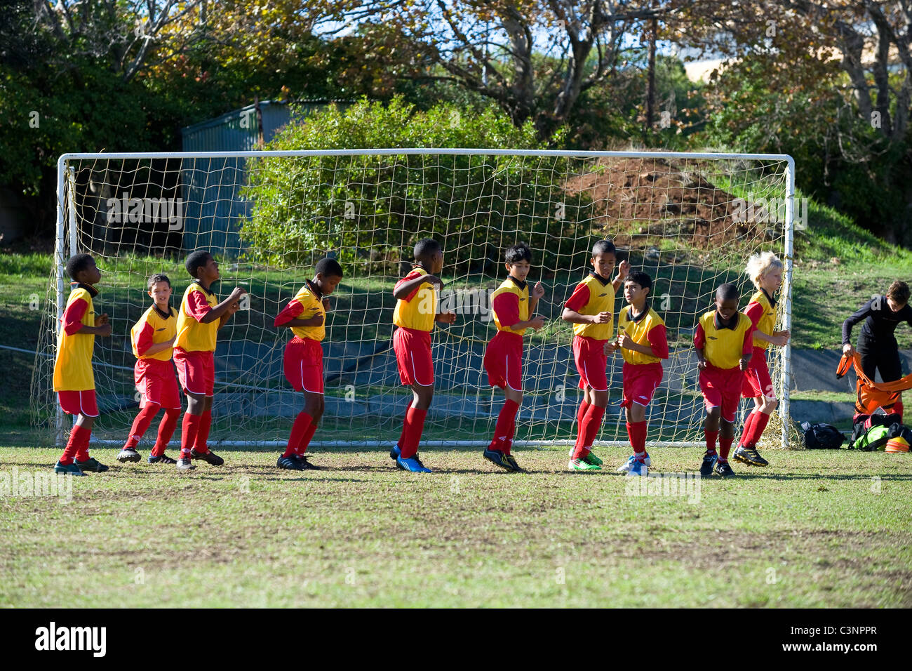 Los jugadores de un equipo de fútbol U11 el calentamiento antes del partido Cape Town South Africa Foto de stock